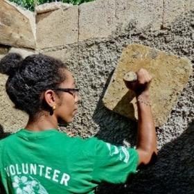 A Projects Abroad volunteer helps with plastering a wall during volunteer building work abroad.